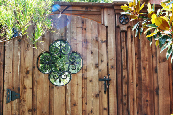 Stained wood fence gate with black clover decorative ornament gate accents and black gate hardware