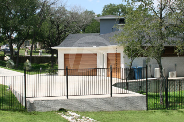 Ornamental black panel perimeter fence with horizontal cedar garage doors