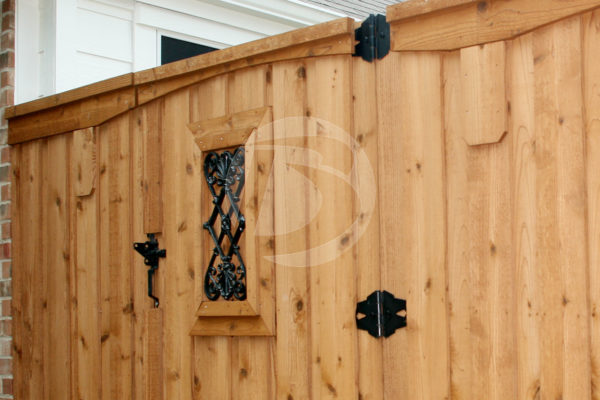 Unstained wood fence with black gate hardware and ornament gate accent and fittings