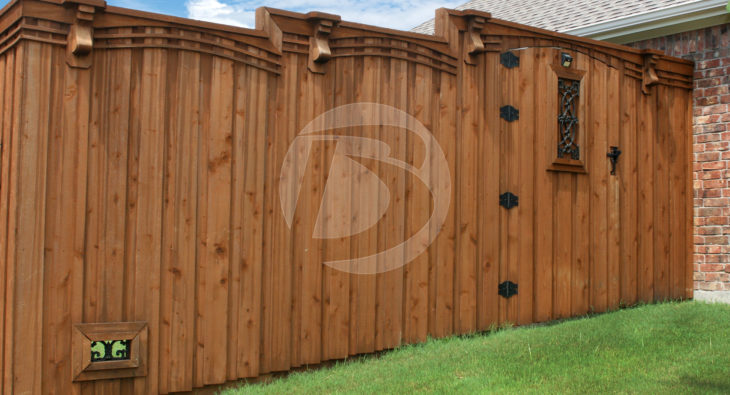 Board on Board staggered height wood fence with black gate hardware and ornamental gate accent