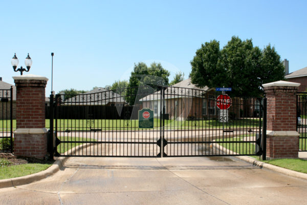 Black swing access controls community entrance gate.