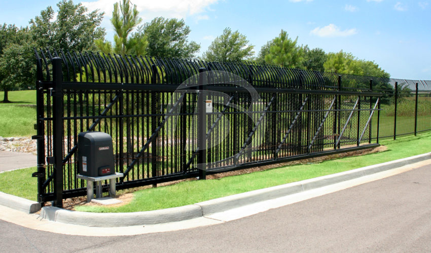 Black perimeter fence with a sliding access controls gate and control box