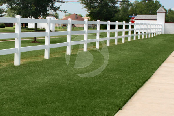White 3 rail vinyl fencing surrounding a neighborhood perimeter