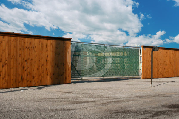 Stained Wood perimeter fence with chain link cantilever access gate.