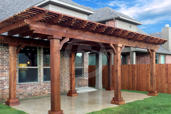 Brown stained cedar pergola in backyard with wood posts and wood corbels