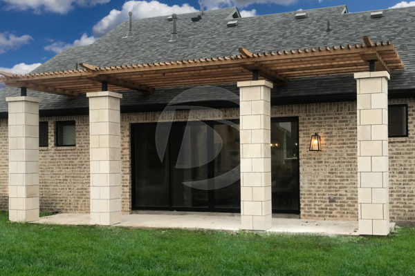 Dark brown stained cedar pergola on stone pillars