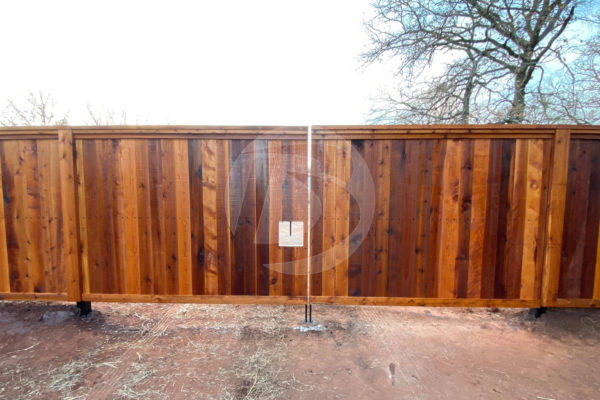 Clear stained cedar fence with closed access controls gate
