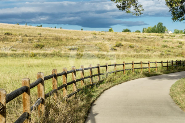Round Split rail fence along a walking path overlooking a field