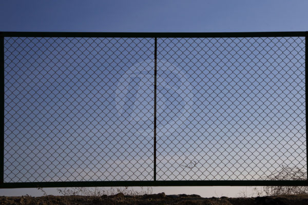Black Chainlink Fence Gate infront of a sunset