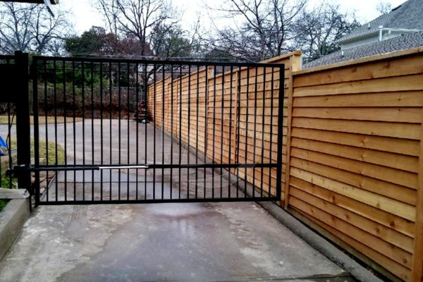 Swing gate attached to unstained cedar horizontal wood fence