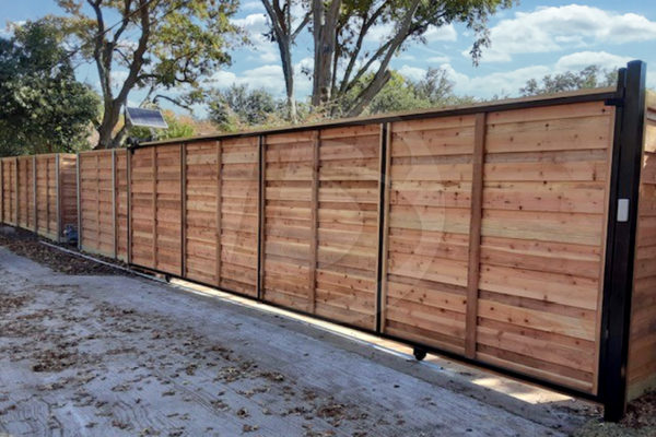 Cedar horizontal install wood fence with a slide access controls gate and a solar panel