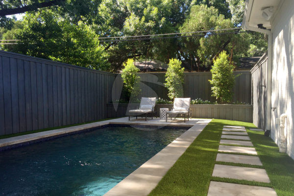 Grey custom stain cedar board on board fence around a pool